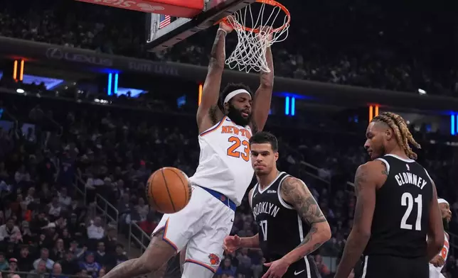 New York Knicks' Mitchell Robinson (23) dunks the ball in front of Brooklyn Nets' Michael Porter Jr. (17) and Noah Clowney (21) during the first half of an NBA basketball game Wednesday, Jan. 21, 2026, in New York. (AP Photo/Frank Franklin II)
