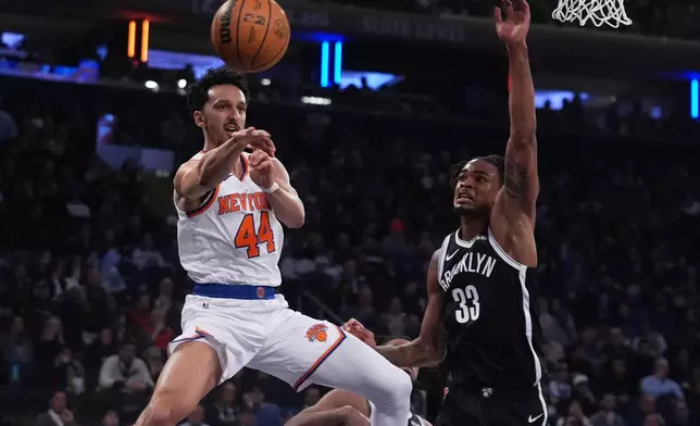 New York Knicks' Landry Shamet (44) passes away from Brooklyn Nets' Nic Claxton (33) during the first half of an NBA basketball game Wednesday, Jan. 21, 2026, in New York. (AP Photo/Frank Franklin II)