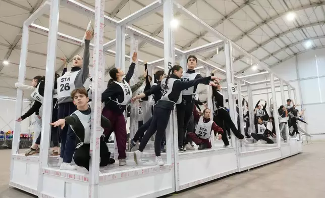 Volunteer dancers perform during rehearsals for the opening ceremony of the Milan Cortina 2026 Winter Olympic Games, at a compound in a big tent next to San Siro Stadium, in Milan, Italy, Saturday, Jan. 24, 2026. (AP Photo/Luca Bruno)