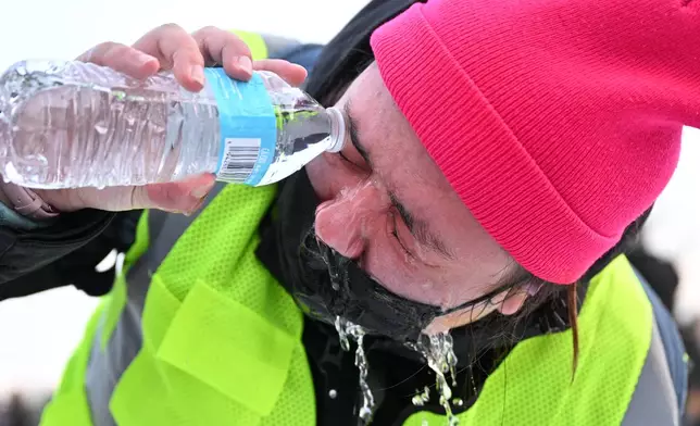 A protester pours water in their eye after confronting law enforcement outside the Bishop Henry Whipple Federal Building, Thursday, Jan. 8, 2026, in Minneapolis, Minn. (AP Photo/Tom Baker)