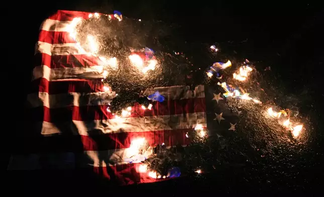 An American flag burns outside the U.S. Immigration and Customs Enforcement facility on Thursday, Jan. 8, 2026, in Portland, Ore. (AP Photo/Jenny Kane)