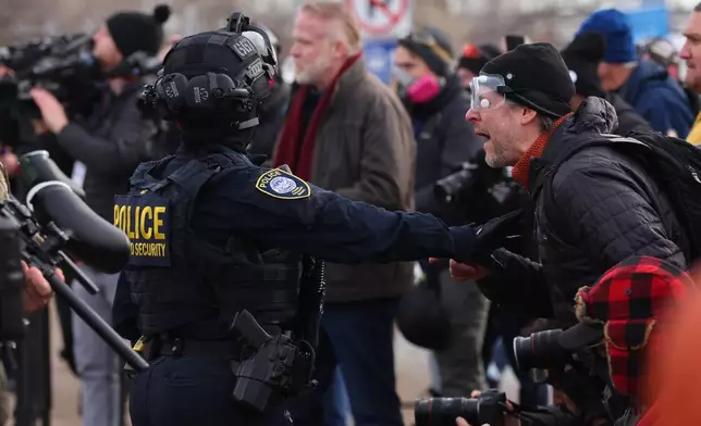 Protesters confront law enforcement outside the Bishop Henry Whipple Federal Building in Minneapolis, Friday, Jan. 9, 2026.(AP Photo/Adam Bettcher)