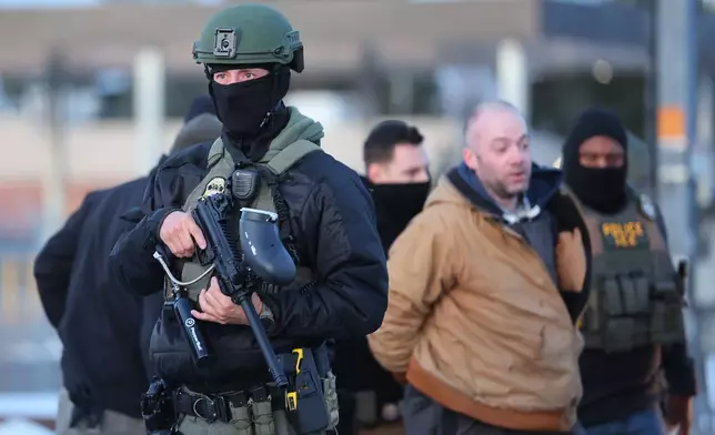 Protesters are arrested by federal agents outside the Bishop Henry Whipple Federal Building in Minneapolis, Friday, Jan. 9, 2026. (AP Photo/Adam Bettcher)