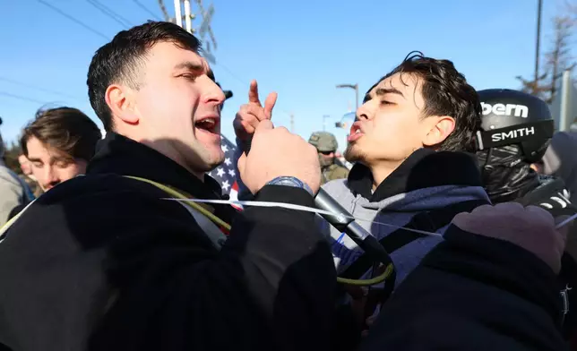 A supporter of United States Immigration and Customs Enforcement argues with a counter protester outside the Bishop Henry Whipple Federal Building in Minneapolis, Friday, Jan. 9, 2026. (AP Photo/Adam Bettcher)