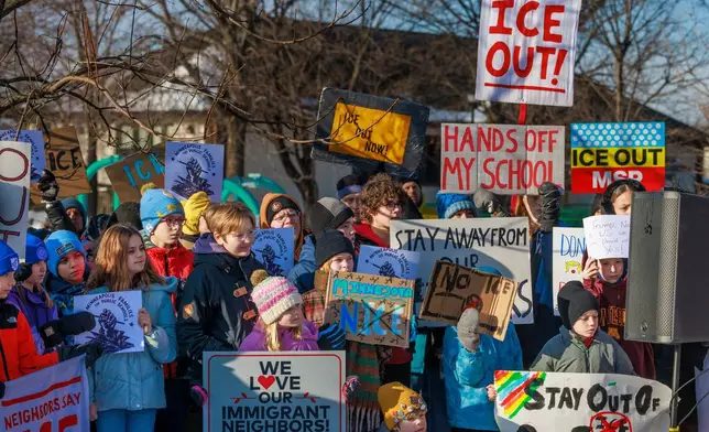 Minneapolis Public Schools families, educators and students hold signs during a news conference at Lake Hiawatha Park in Minneapolis, on Friday, Jan. 9, 2026, demanding Immigration and Customs Enforcement be kept out of schools and Minnesota following the killing of 37-year-old mother Renee Good by federal agents earlier on Wednesday. (Kerem Yücel/Minnesota Public Radio via AP)