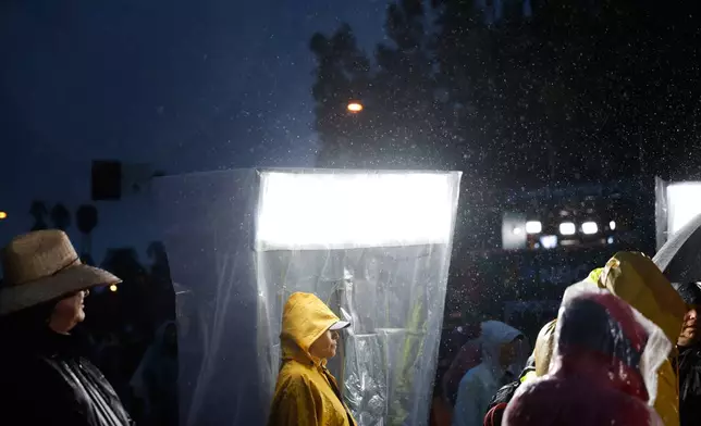 Rain comes down on attendees at the 137th Rose Parade Thursday, Jan. 1, 2026, in Pasadena, Calif. (AP Photo/Caroline Brehman)