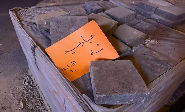 A placard is placed on bricks which reads in Farsi: "Long live the Shah," referring to the Pahlavi dynasty which was toppled by 1979 Islamic Revolution, in an anti-government protest in Tehran, Iran, Friday, Jan. 9, 2026. (AP Photo)