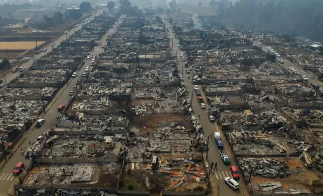 Residential areas burned by wildfires stretch across Tome, Chile, Monday, Jan. 19, 2026. (AP Photo/Javier Torres)
