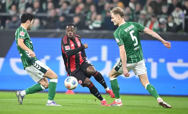 Bremen's Yukinara Sugawara, left, and Amos Pieper challenge Frankfurt's Arnaud Kalimuendo-Muinga for the ball during the Bundesliga soccer match between Werder Bremen and Eintracht Frankfurt in Bremen, Germany, Friday Jan. 16, 2026. (dpa via AP)