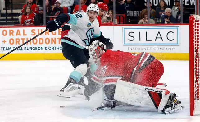 Seattle Kraken's Tye Kartye (12) has his shot frozen by Carolina Hurricanes goaltender Brandon Bussi during the first period of an NHL hockey game in Raleigh, N.C., Saturday, Jan. 10, 2026. (AP Photo/Karl DeBlaker)