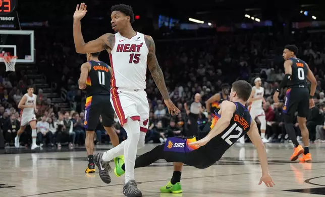 Miami Heat forward Myron Gardner (15) and Phoenix Suns guard Collin Gillespie (12) trade fouls during the first half of an NBA basketball game, Sunday, Jan. 25, 2026, in Phoenix. (AP Photo/Rick Scuteri)