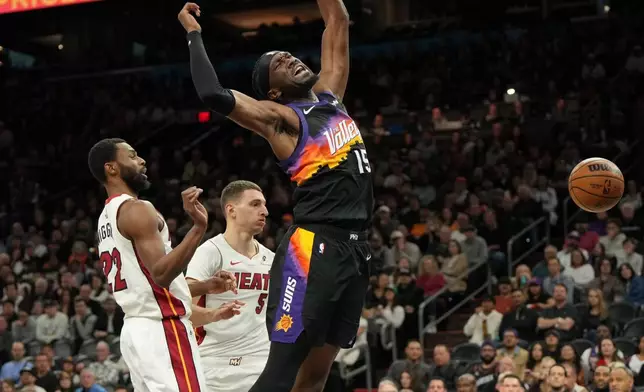 Phoenix Suns center Mark Williams reacts (15) after being fouled by Miami Heat forward Andrew Wiggins, left, during the second half of an NBA basketball game, Sunday, Jan. 25, 2026, in Phoenix. (AP Photo/Rick Scuteri)