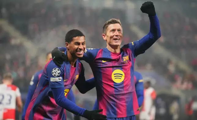 Barcelona's Robert Lewandowski, right, celebrates with his teammate Marcus Rashford after scoring his side's fourth goal during the Champions League opening phase soccer match between Slavia Prague and Barcelona in Prague, Czech Republic, Wednesday, Jan. 21, 2026. (AP Photo/Petr David Josek)