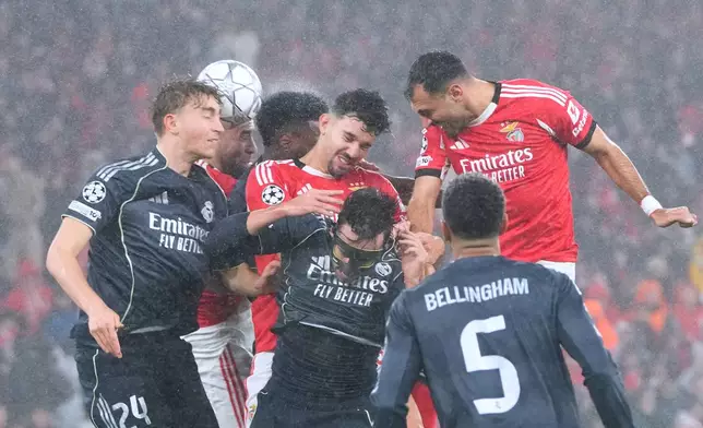 Benfica's Tomas Araujo, center, goes for a header against Real Madrid's Dean Huijsen, left, during a Champions League opening phase soccer match between Benfica and Real Madrid, in Lisbon, Wednesday, Jan. 28, 2026. (AP Photo/Armando Franca)