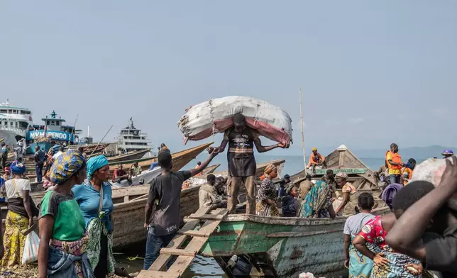 Workers unload goods from boats on the shores of Lake Kivu in Goma, Democratic Republic of the Congo, Monday, Jan. 26, 2026, a year after M23 took control of the city. (AP Photo/Moses Sawasawa)