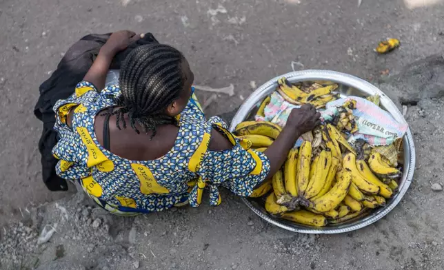 A woman sells bananas on the shores of Lake Kivu in Goma, Democratic Republic of the Congo, Monday, Jan. 26, 2026, a year after M23 took control of the city. (AP Photo/Moses Sawasawa)