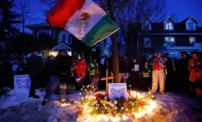 People gather for a vigil after an Immigration and Customs Enforcement officer shot and killed a woman earlier in the day, Wednesday, Jan. 7, 2026, in Minneapolis. (AP Photo/Bruce Kluckhohn)