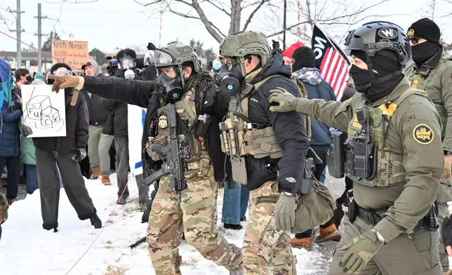 EDS NOTE: OBSCENITY - Federal agents confront protesters outside the Bishop Henry Whipple Federal Building, Thursday, Jan. 8, 2026, in Minneapolis, Minn. (AP Photo/Tom Baker)