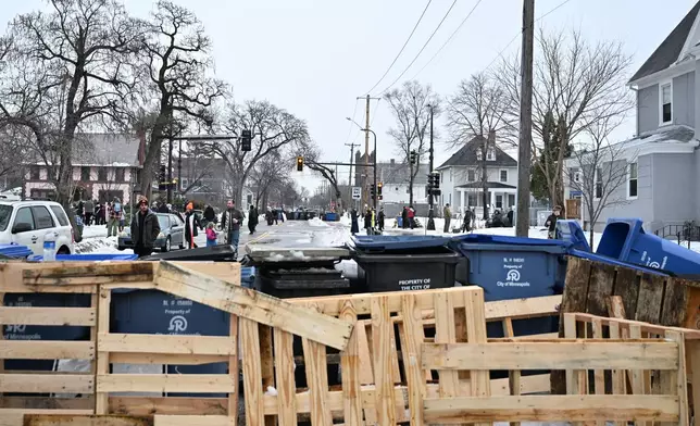 The street is barricaded by a makeshift memorial honoring the victim of a fatal shooting involving federal law enforcement agents, near the site of the shooting, Thursday, Jan. 8, 2026, in Minneapolis. (AP Photo/Tom Baker)