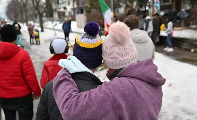 People gather around a makeshift memorial honoring the victim of a fatal shooting involving federal law enforcement agents, inear the site of the shooting, Thursday, Jan. 8, 2026, in Minneapolis. (AP Photo/Tom Baker)