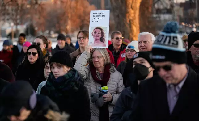 People gather for a vigil honoring Renee Good, who was fatally shot by an ICE officer in Minneapolis earlier in the week, at the Minnesota State Capitol in St. Paul, Minn., Friday, Jan. 9, 2026. (AP Photo/John Locher)