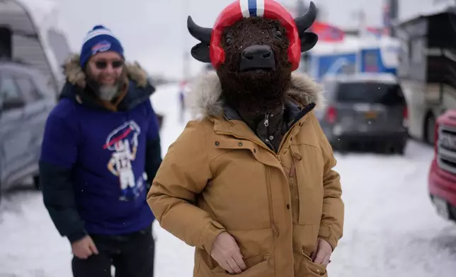 Aga Deters, right, and her husband Fred Deters, walk near Highmark Stadium before an NFL football game between the Buffalo Bills and the New York Jets, Sunday, Jan. 4, 2026, in Orchard Park, N.Y. (AP Photo/Carolyn Kaster)