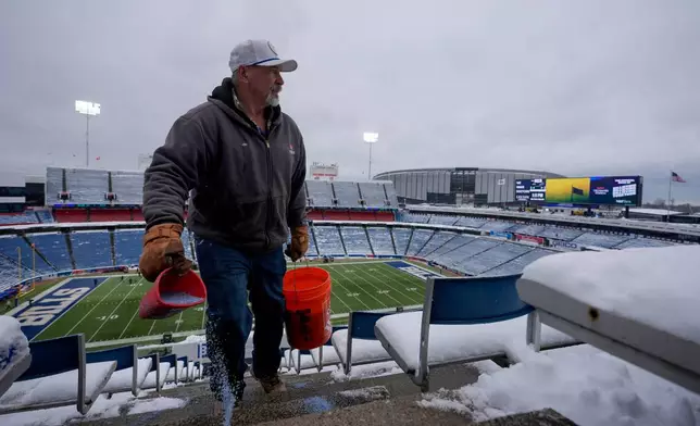 Salt crew member Jim Earl sprinkles salt in the upper deck before an NFL football game between the Buffalo Bills and the New York Jets at Highmark Stadium, Sunday, Jan. 4, 2026, in Orchard Park, N.Y. (AP Photo/Carolyn Kaster)
