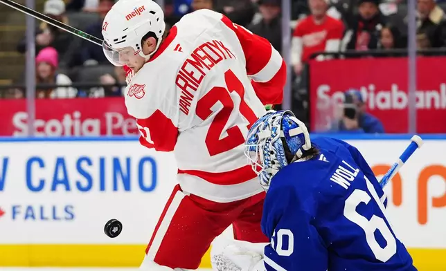 Toronto Maple Leafs goaltender Joseph Woll (60) makes a save as Detroit Red Wings' James van Riemsdyk (21) looks for the rebound during the first period of an NHL hockey game in Toronto, Wednesday, Jan. 21, 2026. (Frank Gunn/The Canadian Press via AP)