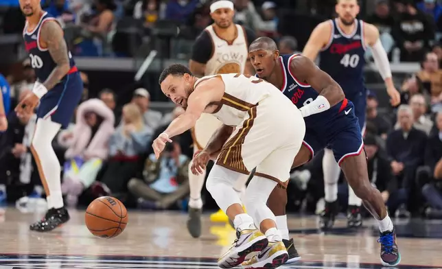 Golden State Warriors guard Stephen Curry (30) reaches for a loose ball against Los Angeles Clippers guard Kris Dunn (8) during the first half of an NBA basketball game Monday, Jan. 5, 2026, in Inglewood, Calif. (AP Photo/Jae C. Hong)
