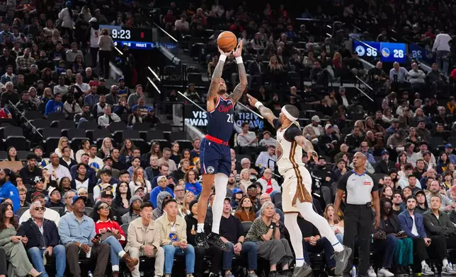 Los Angeles Clippers forward/center John Collins (20) shoots for a three-point basket under pressure by Golden State Warriors guard Gary Payton II (0) during the first half of an NBA basketball game Monday, Jan. 5, 2026, in Inglewood, Calif. (AP Photo/Jae C. Hong)