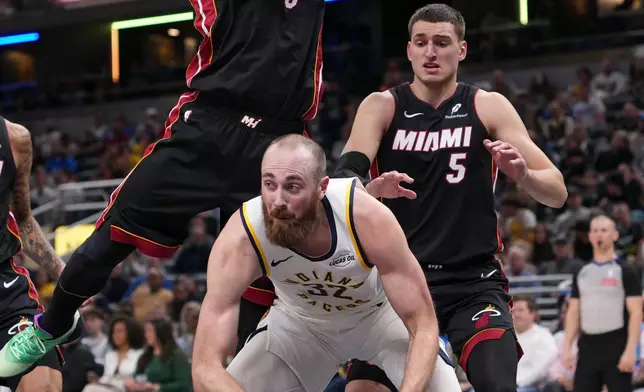 Miami Heat guard Pelle Larsson (9) makes contact with Indiana Pacers center Jay Huff (32) during the first half of an NBA basketball game in Indianapolis, Saturday, Jan. 10, 2026. (AP Photo/AJ Mast)