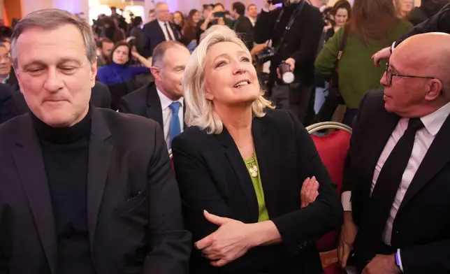 Far-right leader Marine Le Pen, center, is framed by Louis Aliot, left, and conservative lawmaker Eric Ciotti during National Rally president Jordan Bardella's New Year address to the press, Monday, Jan. 12, 2026 in Paris. (AP Photo/Christophe Ena)