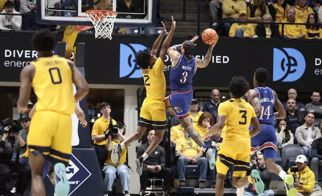Kansas guard Tre White (3) is shoots while defended by West Virginia guard Amir Jenkins (2) during the first half of an NCAA college basketball game Saturday, Jan. 10, 2026, in Morgantown, W.Va. (AP Photo/Kathleen Batten)