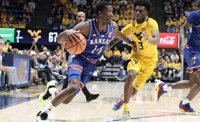 Kansas guard Melvin Council Jr. (14) is defended by West Virginia guard Honor Huff (3) during the second half of an NCAA college basketball game Saturday, Jan. 10, 2026, in Morgantown, W.Va. (AP Photo/Kathleen Batten)