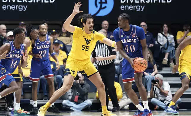 Kansas forward Flory Bidunga (40) is defended by West Virginia center Harlan Obioha (55) during the first half of an NCAA college basketball game Saturday, Jan. 10, 2026, in Morgantown, W.Va. (AP Photo/Kathleen Batten)