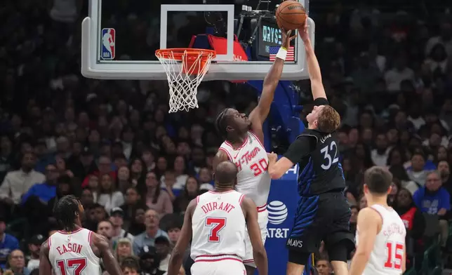 Houston Rockets center Clint Capela (30) blocks a shot by Dallas Mavericks forward Cooper Flagg (32) during the first half of an NBA basketball game Saturday, Jan. 3, 2026, in Dallas. (AP Photo/Julio Cortez)