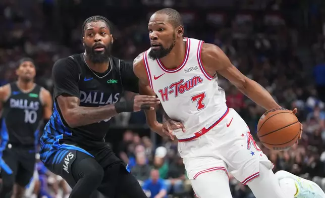 Houston Rockets forward Kevin Durant, right, drives to the basket against Dallas Mavericks forward Naji Marshall during the first half of an NBA basketball game Saturday, Jan. 3, 2026, in Dallas. (AP Photo/Julio Cortez)