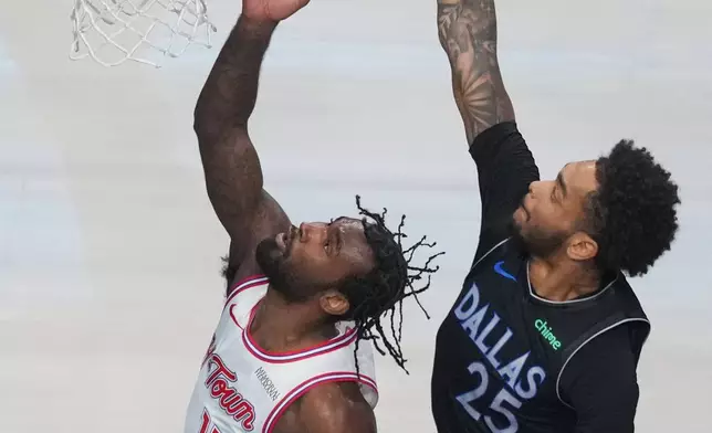 Dallas Mavericks forward P.J. Washington (25) prepares to block a shot by Houston Rockets forward Tari Eason (17) during the first half of an NBA basketball game Saturday, Jan. 3, 2026, in Dallas. (AP Photo/Julio Cortez)