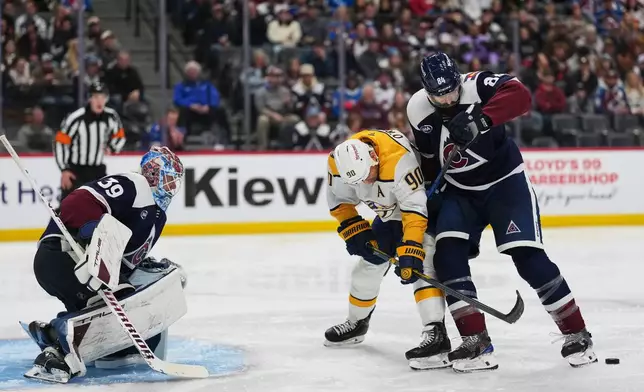 Colorado Avalanche defenseman Brent Burns, right, uses the blade of his skate to block a pass intended for Nashville Predators center Ryan O'Reilly (90) as Avalanche goaltender MacKenzie Blackwood (39) protects the net in the second period of an NHL hockey game Friday, Jan. 16, 2026, in Denver. (AP Photo/David Zalubowski)