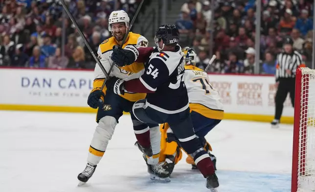 Nashville Predators defenseman Roman Josi, left, battles for position with Colorado Avalanche center Gavin Brindley (54) in the first period of an NHL hockey game Friday, Jan. 16, 2026, in Denver. (AP Photo/David Zalubowski)