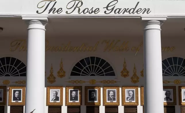 FILE - A sign for the Rose Garden is seen near the Presidential Walk of Fame on the Colonnade at the White House, Jan. 13, 2026, in Washington. (AP Photo/Mark Schiefelbein, File)