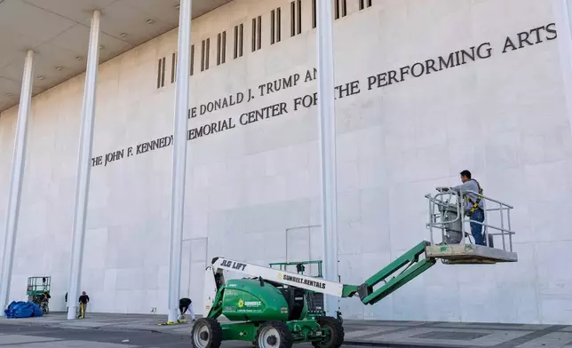 FILE - Workers add President Donald Trump's name to the John F. Kennedy Memorial Center for the Performing Arts, after a Trump-appointed board voted to rename the institution, in Washington, Dec. 19, 2025. (AP Photo/J. Scott Applewhite, File)