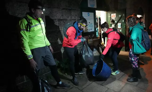 Participants in the Goodgym group collect litter from the riverbank to keep the River Thames free of plastic and other waste in London, Wednesday, Jan. 14, 2026. (AP Photo/Kirsty Wigglesworth)