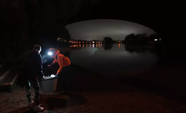 Participants in the Goodgym group collect litter from the riverbank to keep the River Thames free of plastic and other waste in London, Wednesday, Jan. 14, 2026. (AP Photo/Kirsty Wigglesworth)
