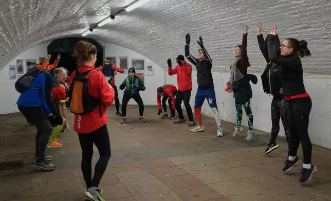 Participants in the Goodgym group exercise after collecting litter to keep the River Thames free of plastic and other waste in London, Wednesday, Jan. 14, 2026. (AP Photo/Kirsty Wigglesworth)