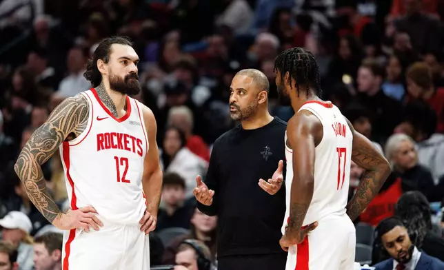 Houston Rockets head coach Ime Udoka, center, speaks with Houston Rockets center Steven Adams left, and forward Tari Eason, right, during the second half of an NBA basketball game against the Portland Trail Blazers, Friday, Jan. 9, 2026, in Portland, Ore. (AP Photo/Howard Lao)