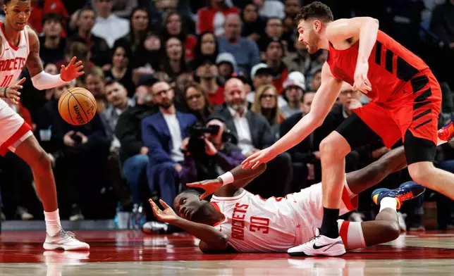 Houston Rockets center Clint Capela (30) dives for the ball during the second half of an NBA basketball game against the Portland Trail Blazers, Friday, Jan. 9, 2026, in Portland, Ore. (AP Photo/Howard Lao)