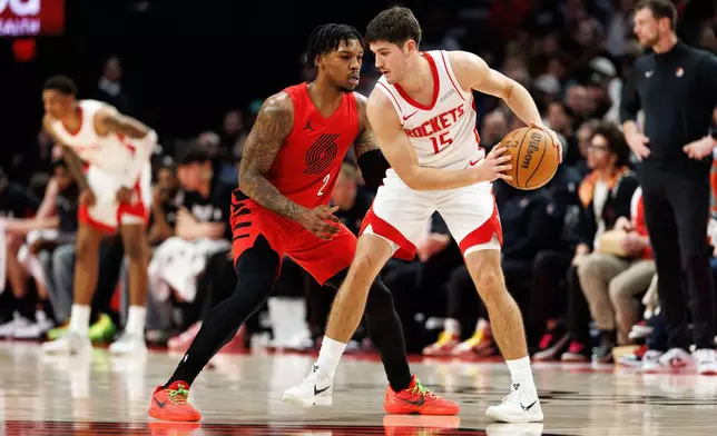 Houston Rockets guard Reed Sheppard, right, keeps the ball from Portland Trail Blazers guard Caleb Love, left, during the first half of an NBA basketball game Friday, Jan. 9, 2026, in Portland, Ore. (AP Photo/Howard Lao)