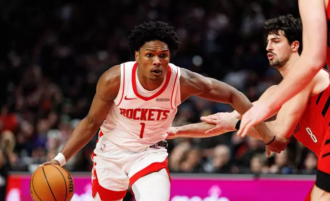 Houston Rockets guard Amen Thompson, left, dribbles against Portland Trail Blazers forward Deni Avdija, right. during the second half of an NBA basketball game Friday, Jan. 9, 2026, in Portland, Ore. (AP Photo/Howard Lao)