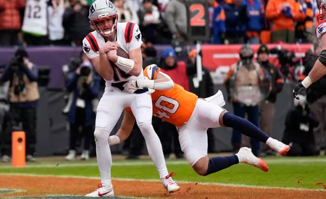 New England Patriots quarterback Drake Maye scores past Denver Broncos linebacker Justin Strnad during the first the half of the AFC Championship NFL football game, Sunday, Jan. 25, 2026, in Denver. (AP Photo/John Locher)
